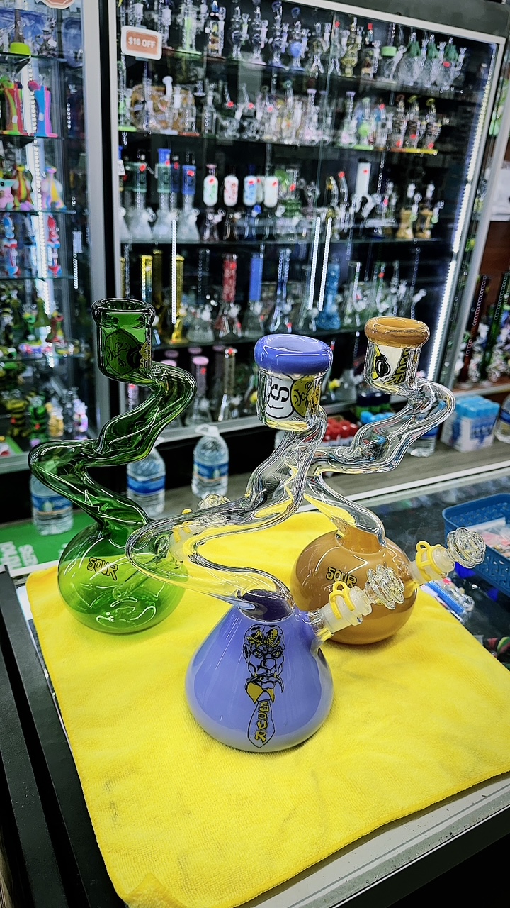 A counter with a yellow table cloth and some glass vases